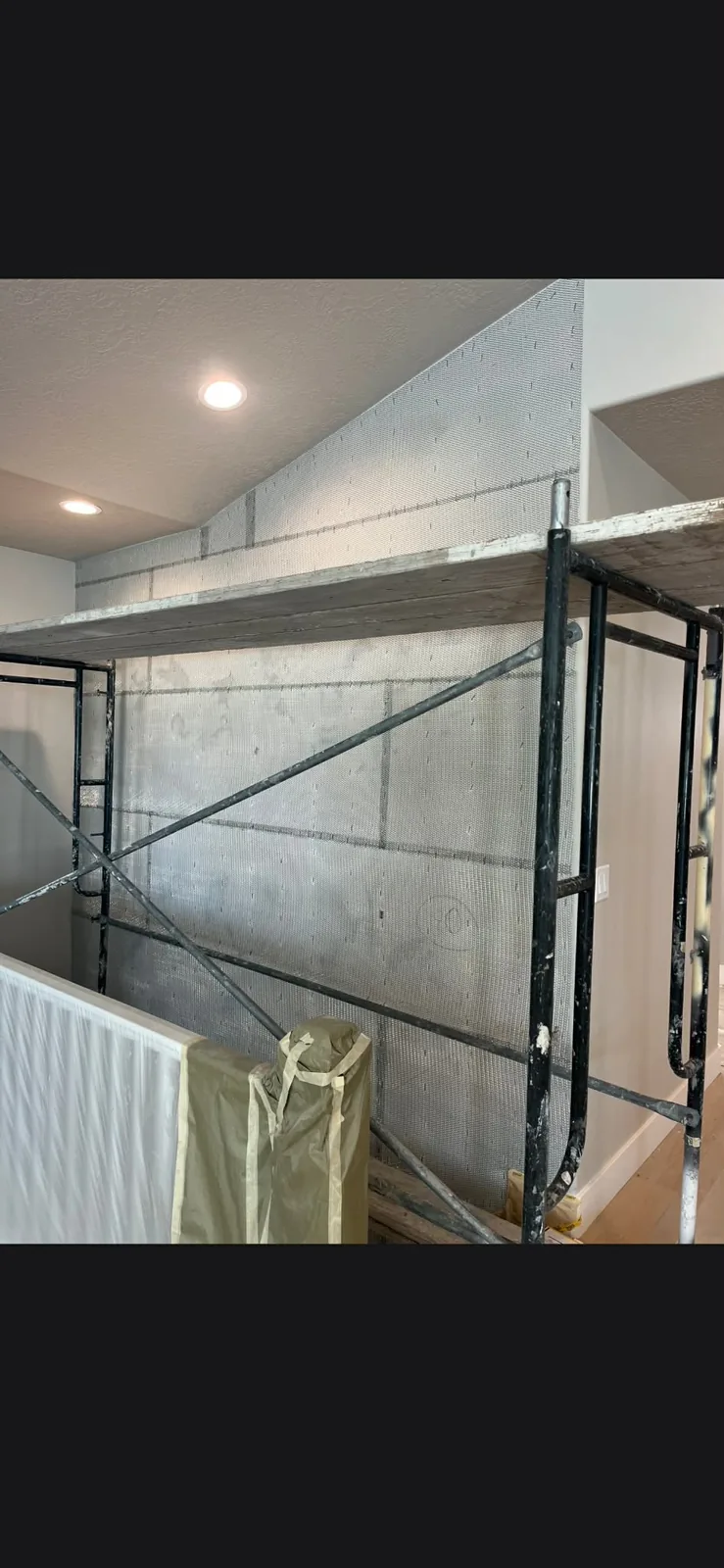 Interior wall lathed and meshed with scaffold set for stucco base coat preparation