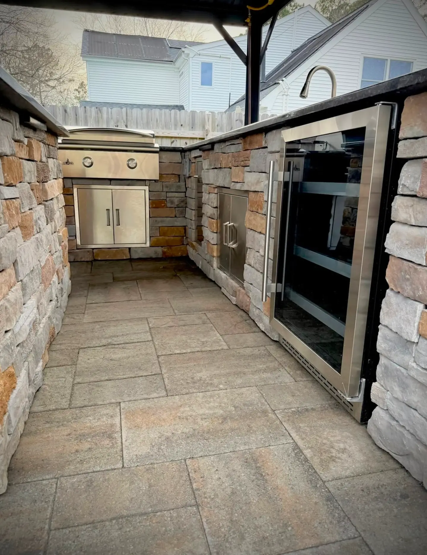 Outdoor kitchen build-out with stone veneer and appliances